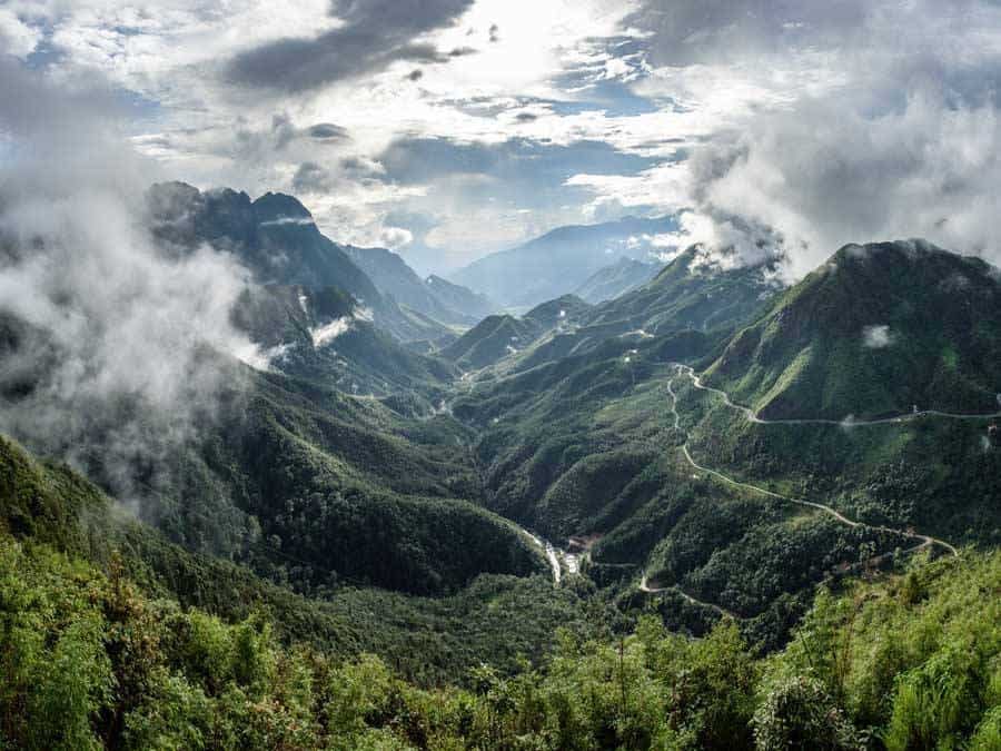 The scenic drive along Tram Ton Pass provides numerous photo opportunities amidst lush valleys and towering mountains.