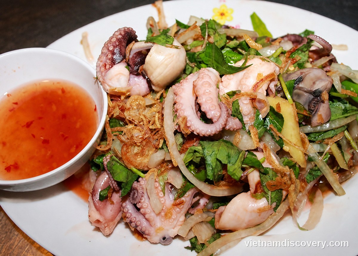 Octopus mixed with onion, herbs and fried spring onion, with a bowl of dipping sauce