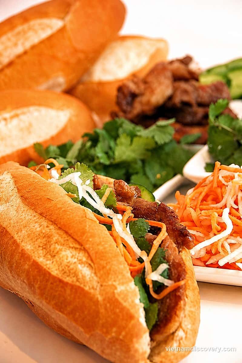 A bánh mì with grilled pork, pickled carrot and herbs