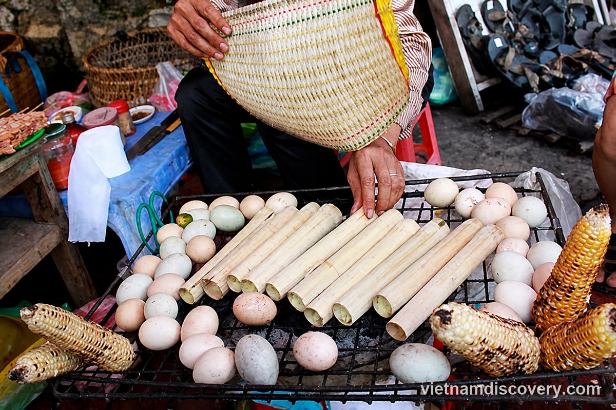 Tubes of lam rice cooking over charcoal