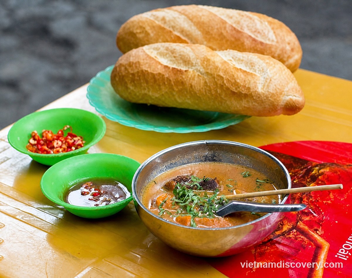 Phá lấu served with bread, chilli and tamarind fish sauce
