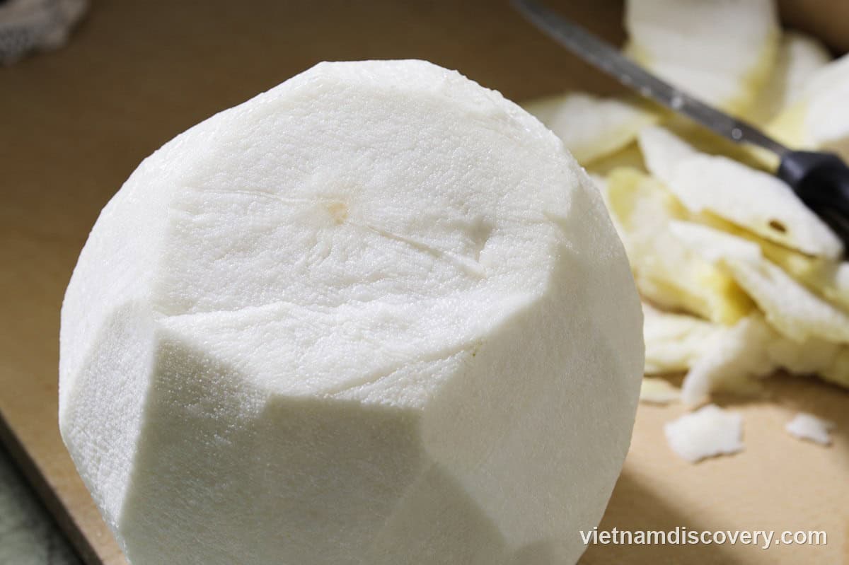 Peeling the green skin off the pomelo