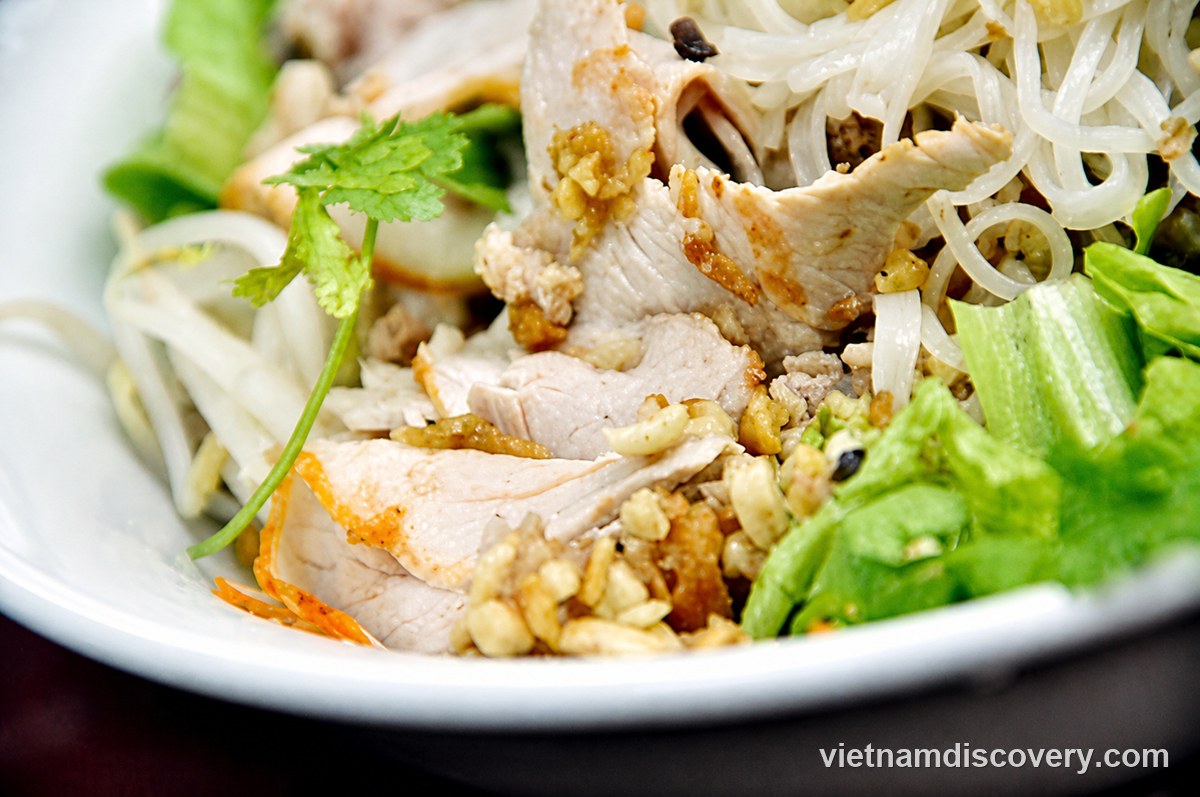 Pho noodles with sliced meat, peanuts and herbs