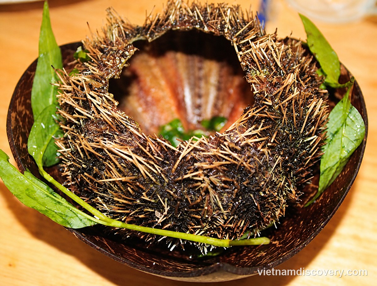 An opened sea urchin in a coconut-shell bowl with green leaves
