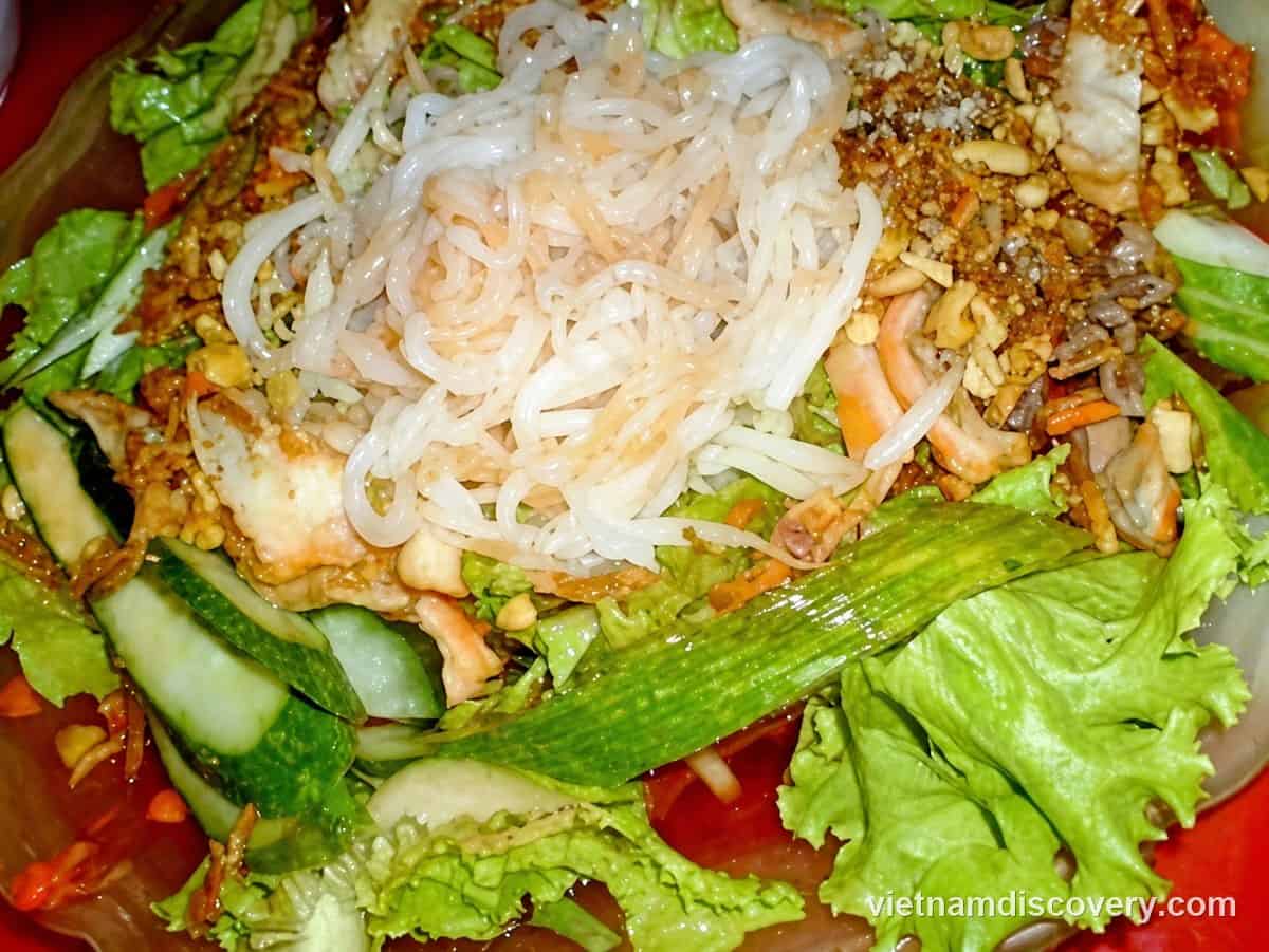 Phở chua topped with noodles, peanuts, lettuce and cucumber